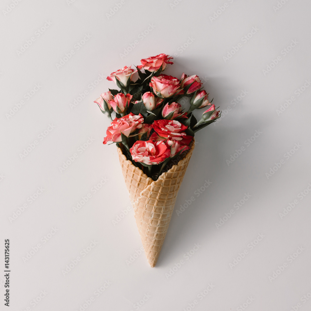 Ice cream cone with colorful flowers on white background. Flat lay. Minimal summer concept. Ice cream cone with colorful flowers on white background. Flat lay. Minimal summer concept.
