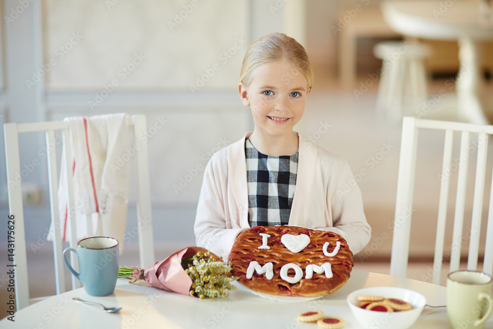 Happy child showing baked pie and looking at camera Happy child showing baked pie and looking at camera