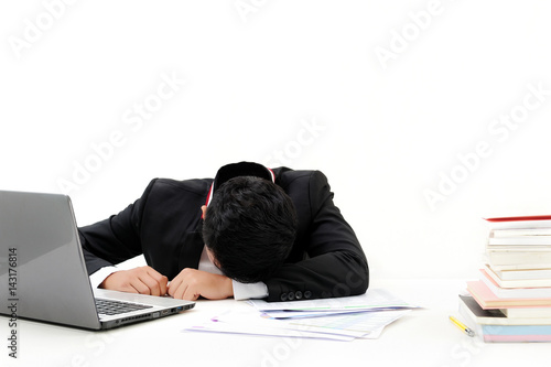 young asia businessman is sleeping at desk office with laptop, pen and documents on white background
