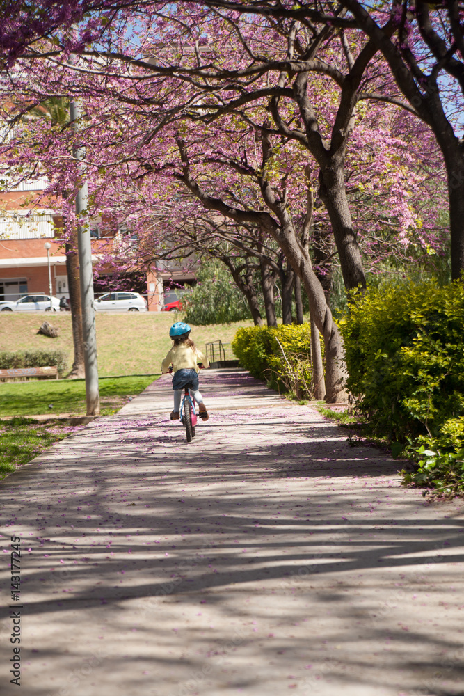 Fototapeta premium Little girl with her bike in the city