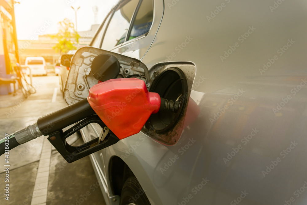 car refilling fuel in petrol station close up and red color dispenser  flare light
