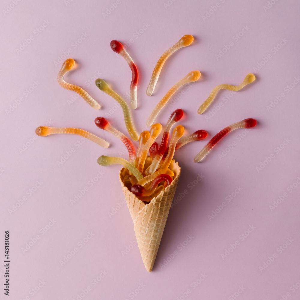 Ice cream cone with gummy candy on pastel pink background. Minimal food concept. Flat lay. Ice cream cone with gummy candy on pastel pink background. Minimal food concept. Flat lay.