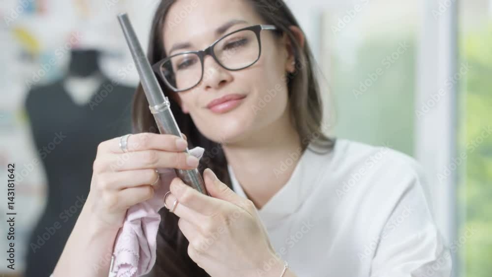 Jewelry designer working in studio using a tool to check size & quality of a ring. Jewelry designer working in studio using a tool to check size & quality of a ring.