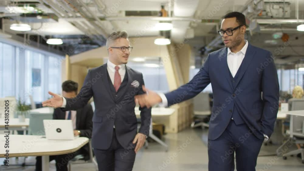 Smart executive business managers walking through modern office Smart executive business managers walking through modern office