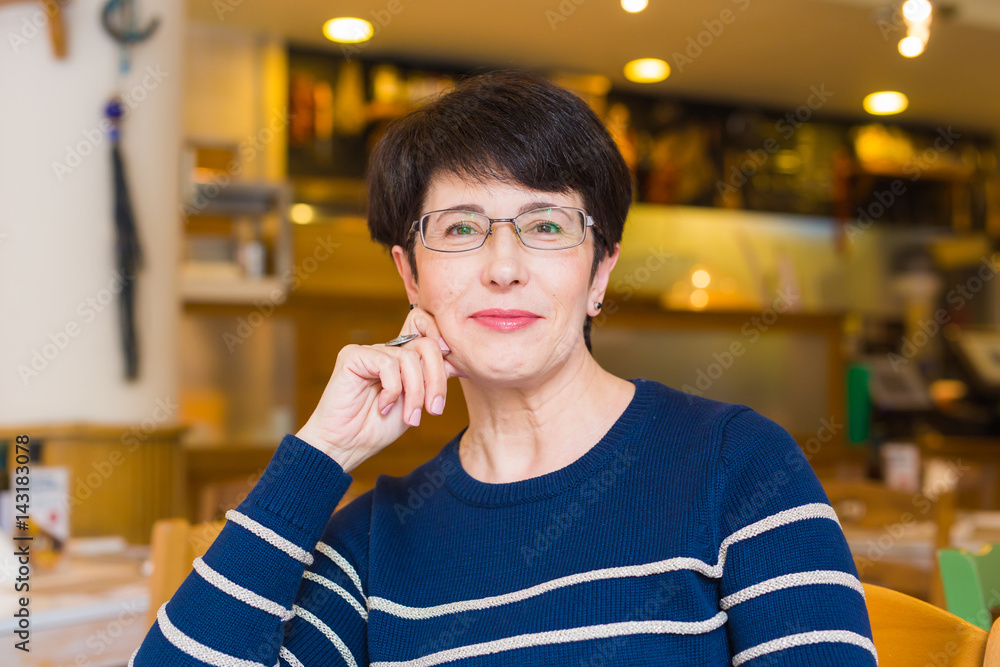 Portrait of woman sitting at table in cafe. Portrait of woman sitting at table in cafe.
