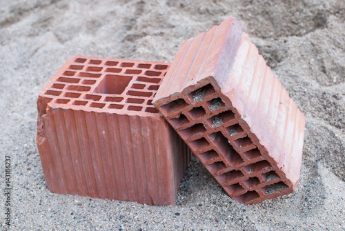 Two clay building blocks isolated on the sand