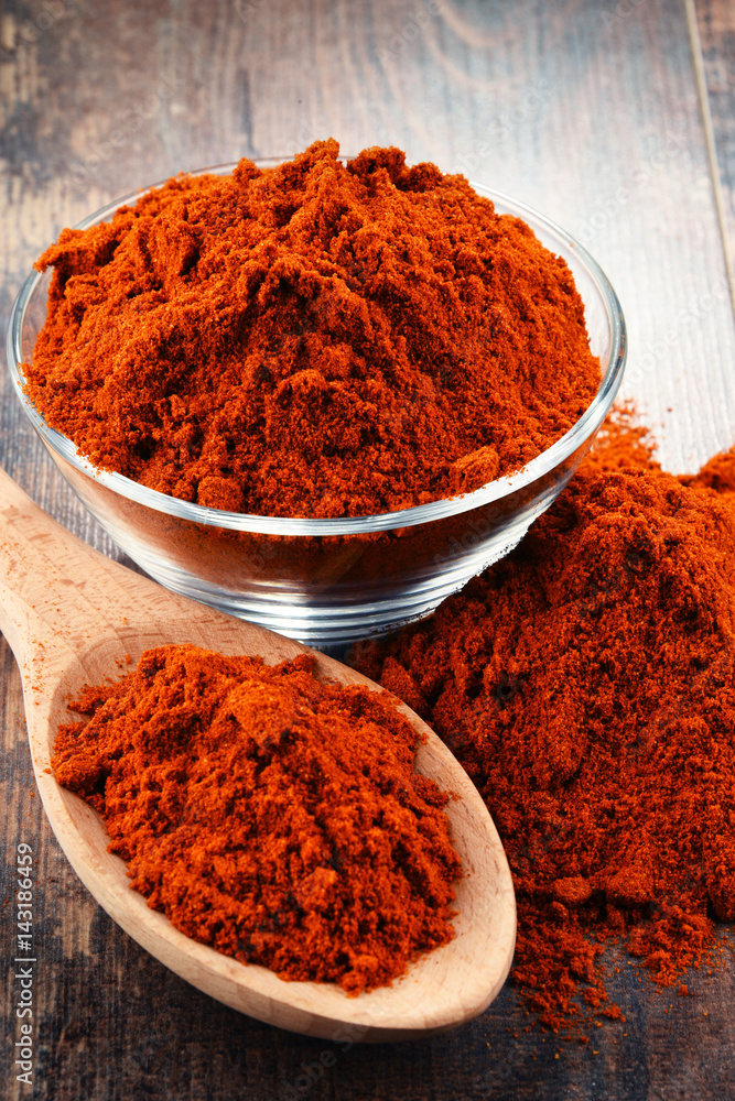 Composition with bowl of chili powder on wooden table Composition with bowl of chili powder on wooden table