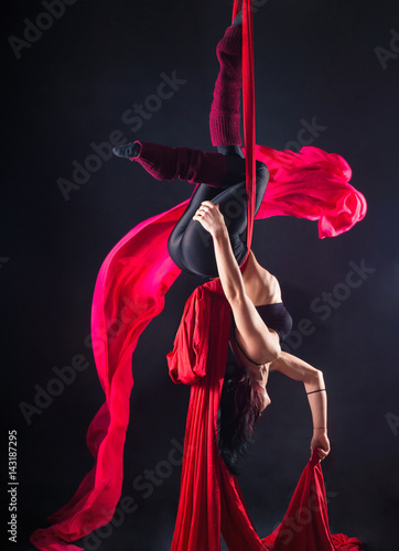 The woman is engaged in aerial acrobatics.