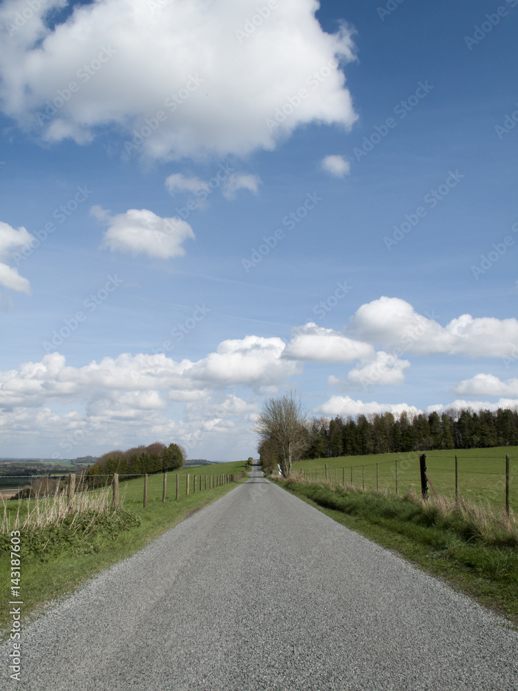Single lane country road through countryside and farmland