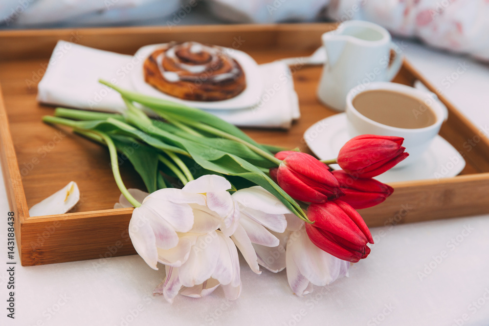 Breakfast in bed with coffee and flowers 