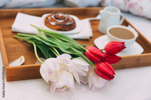Breakfast in bed with coffee and flowers 