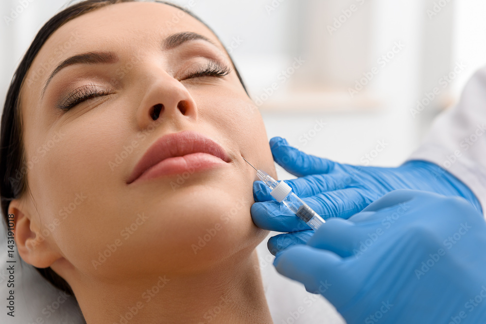 Calm woman during injection in face Calm woman during injection in face
