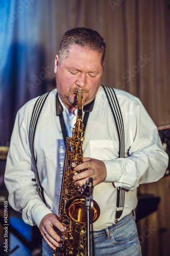 Concert in the restaurant. A middle-aged man, of European appearance, plays the saxophone.