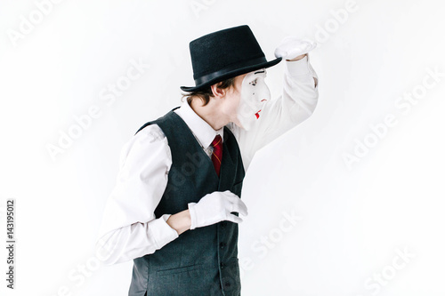 Funny mime in black hat looks far way on white background © IVASHstudio