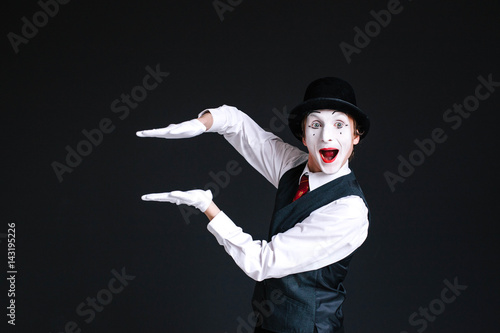 Mime holds his palms parallel in the air