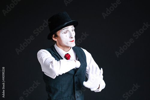 Confident mime takes something from his pocket