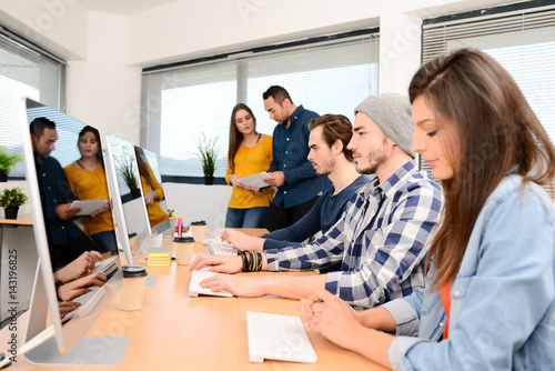 group of five young people student with teacher in computer school classroom learning programming with desktop computer in a row