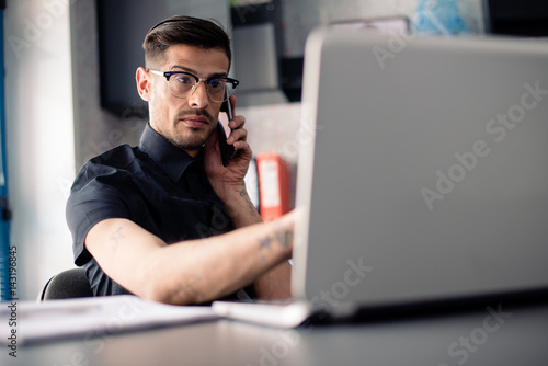 Businessman uses laptop and phone