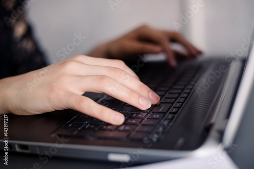 Hands write on the keyboard of a laptop