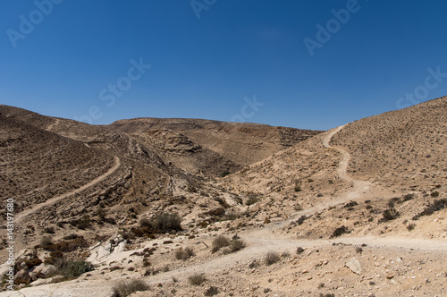 A hilly stone desert, with roads.