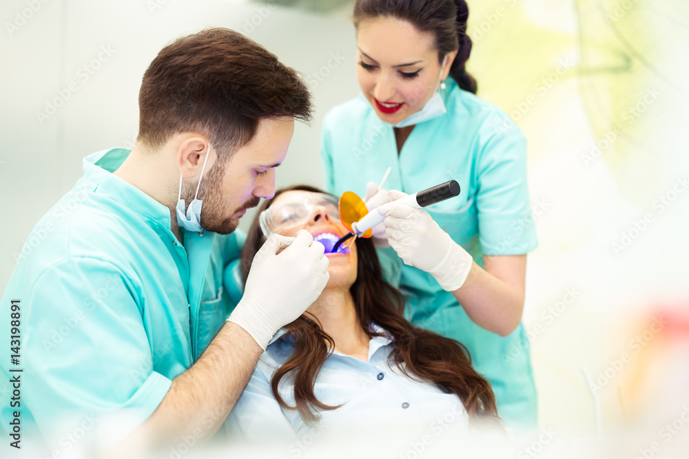 Fototapeta premium A dentist with assistant working on a patient