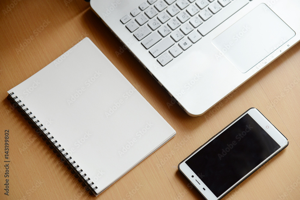 computer notebook with smartphone and notebook on wooden background computer notebook with smartphone and notebook on wooden background