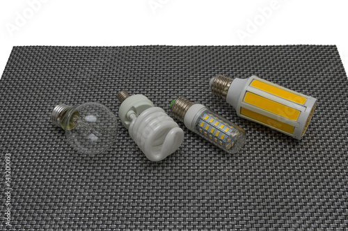 Tablou pe pânză Four electric lamps on a dark background, a glow lamp, fluorescent, LED