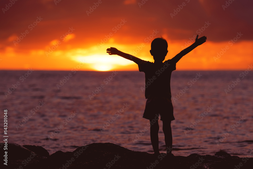 Childhood concept with happy child at sunset beach