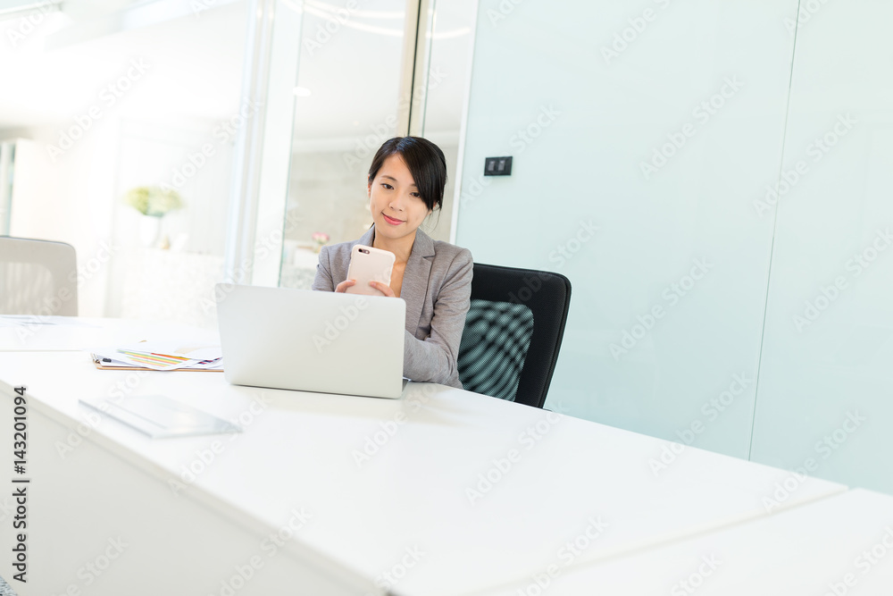 Business woman text on cellphone in office Business woman text on cellphone in office