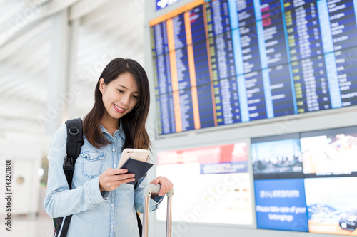Young woman using cellphone in airport