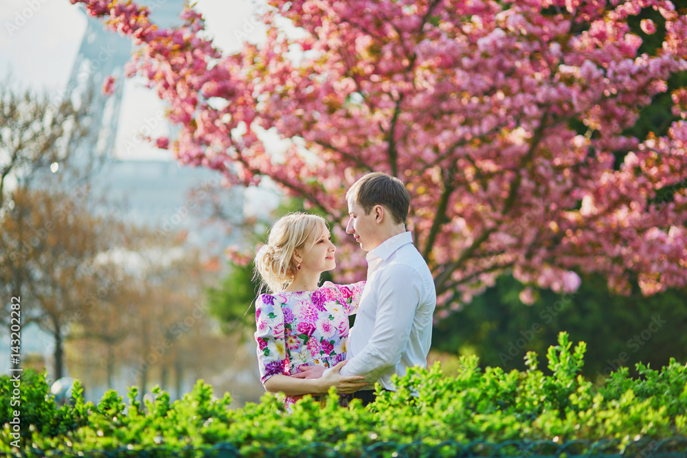 Fototapeta premium Couple in front of the Eiffel tower on a spring day in Paris, France