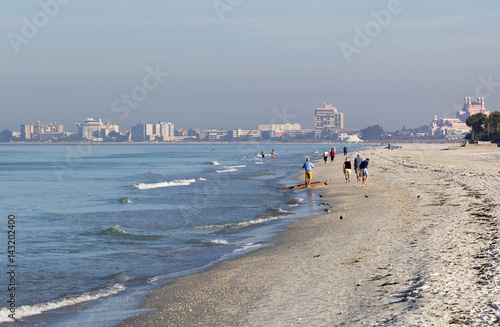 St. Pete Beach, Florida, January 2017: People walking in the surf on St. Pete Beach, Florida looking for shells on a sunny day after a strong wind storm at St. Pete Beach, Florida. photo