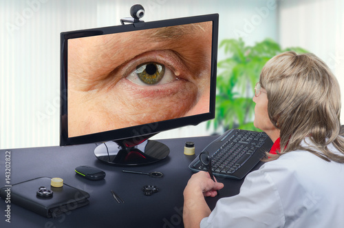 Telemedicine ophthalmologist observes eyelid cyst on computer photo