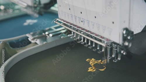 Embroidery machine on T-shirt in Textile Industry at Garment Manufacturers. Machine embroidery is embroidery process whereby sewing machine or embroidery machine is used to create patterns on textiles photo