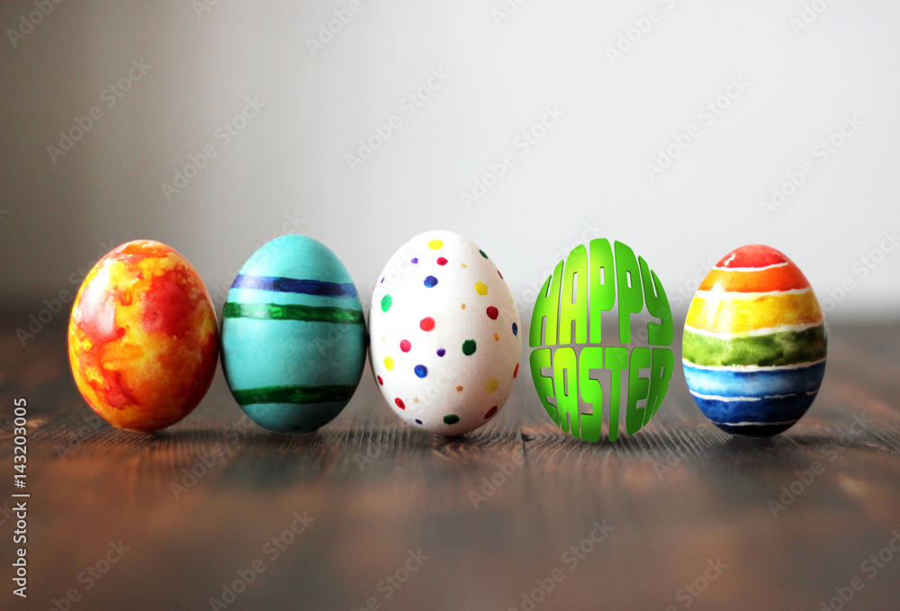 Easter colorful eggs on wooden background with egg shaped words Happy Easter.