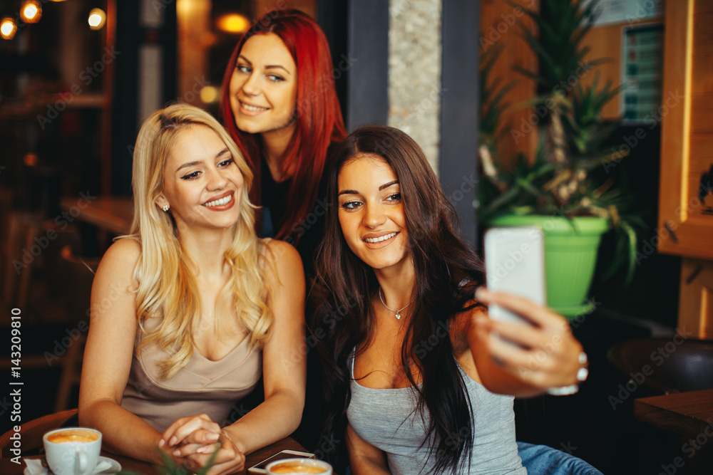 Three beautiful young woman doing selfie in cafe Three beautiful young woman doing selfie in cafe