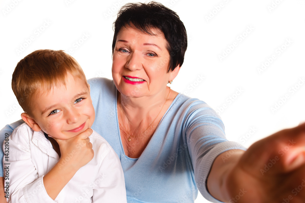 Grandmother hugging her grandson on a white background and making selfie Grandmother hugging her grandson on a white background and making selfie