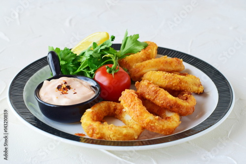 Calamary rings fried with spicy souce and rocca. Mediterranean lifestyle. Healthy food