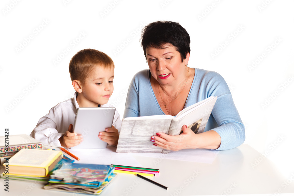 Grandmother with grandson learn and draw at table on a white background Grandmother with grandson learn and draw at table on a white background