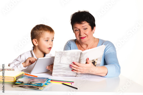 Grandmother with grandson learn and draw at table on a white background