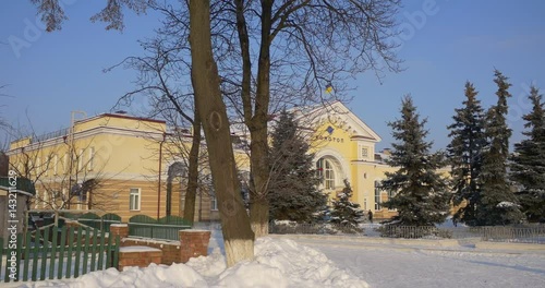 High Fir Trees Standing Before an Impressive Railway Station Building in Konotop, Ukraine, With Its Ukrainian Barokko Style Exterier in Winter photo