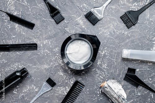 hair dye with brush on gray table background top view
