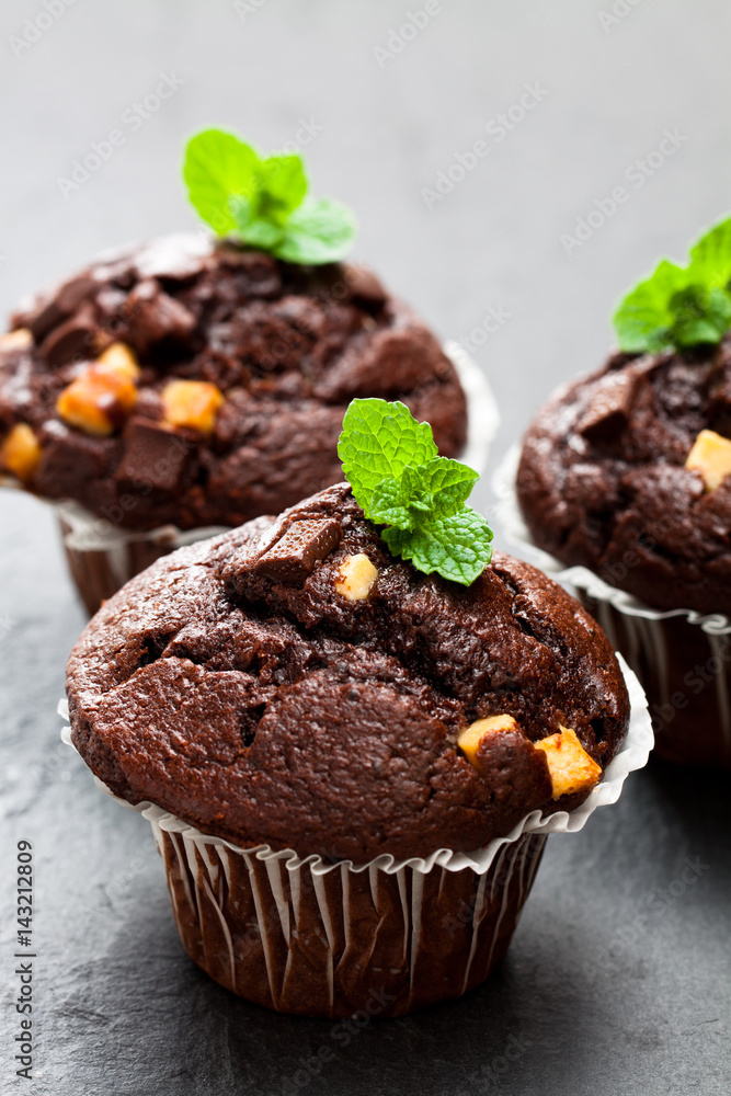Triple chocolate muffins on black stone background Triple chocolate muffins on black stone background