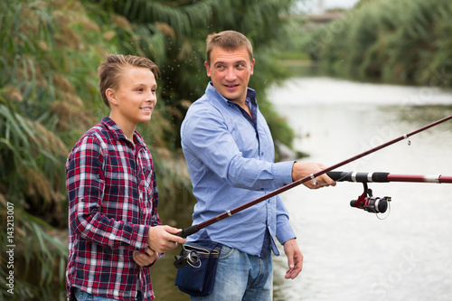 father and son fishing together on lake .