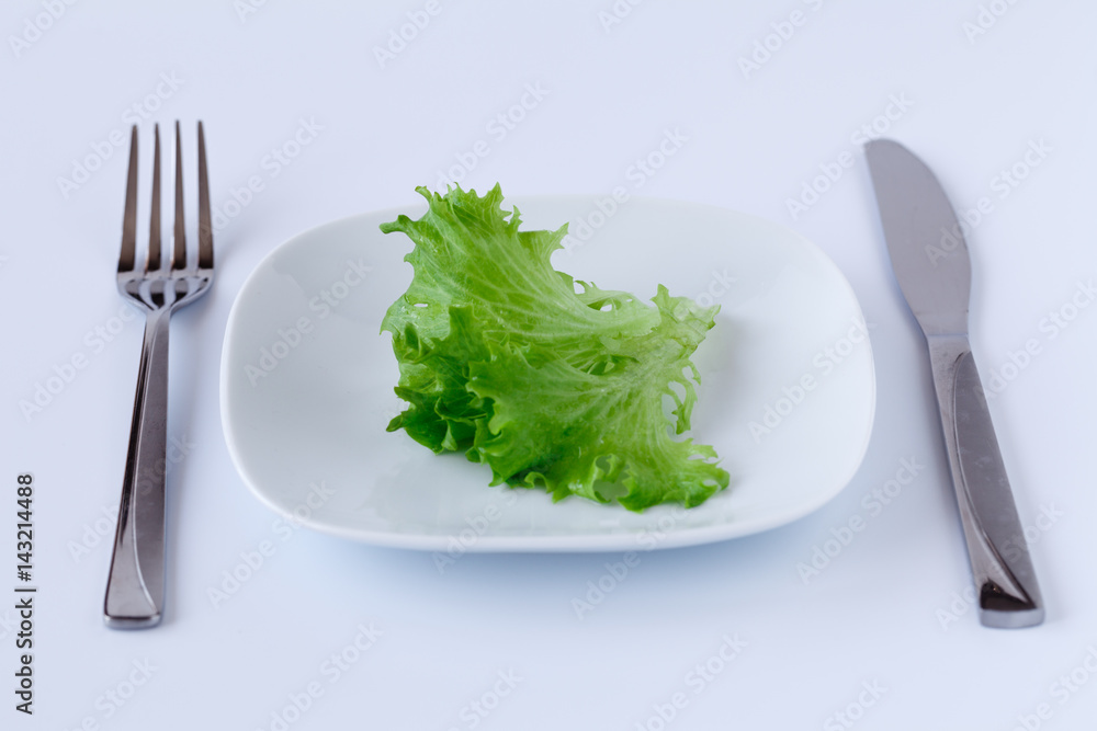Lettuce on a plate with a knife and fork. Lettuce on a plate with a knife and fork.