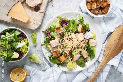 Caesar salad in white plate. Top view