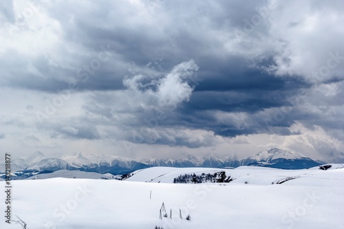 Белые облака на пасмурном небе над снежными горами, природа Северного Кавказа © Ivan_Gatsenko