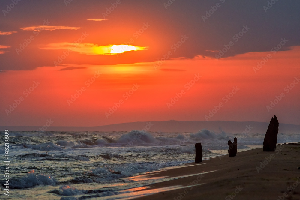 Beautiful sea sunset with breaking waves onto sandy beach of Black sea shore. Scenic landscape