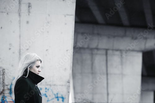 Cute blond girl in front of futuristic concrete structure © qunamax