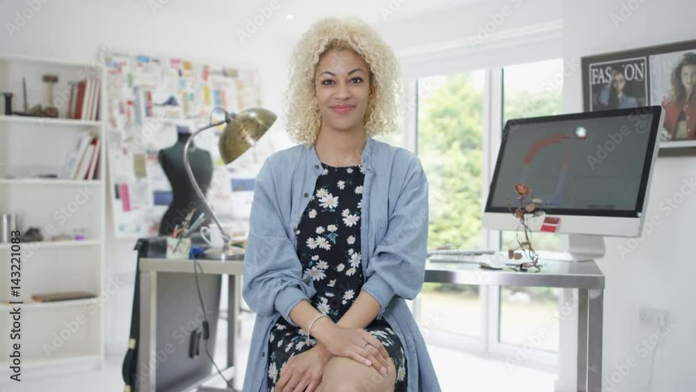 Portrait smiling designer sitting at her desk in studio. Portrait smiling designer sitting at her desk in studio.